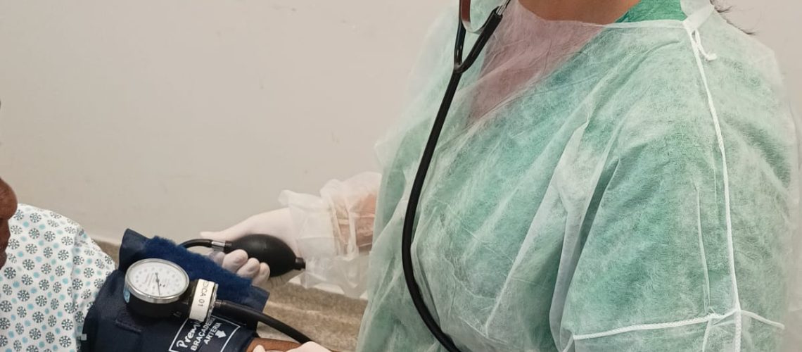Na imagem, enfermeira afere pressão arterial de paciente